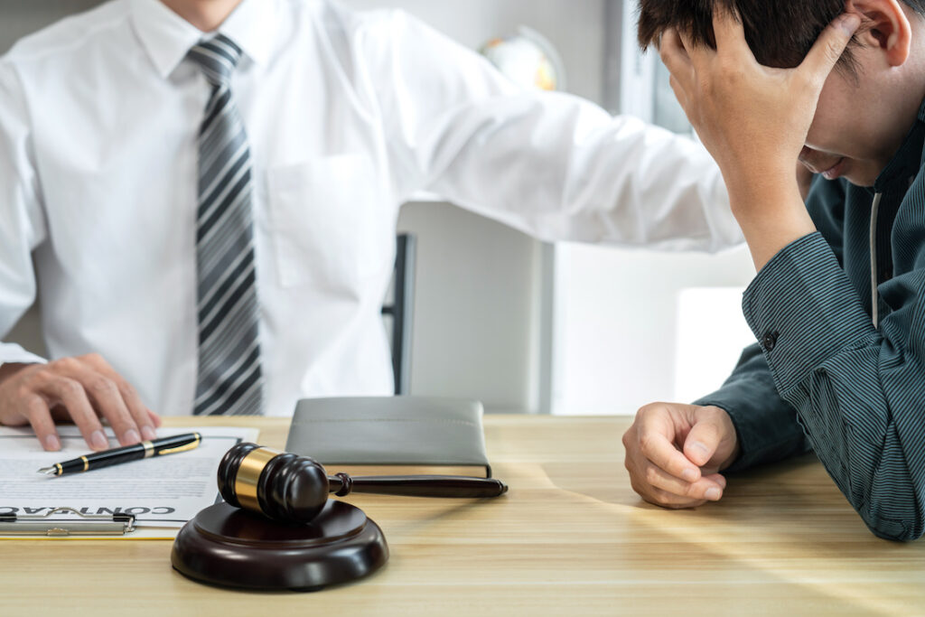 Male lawyer is meeting with businessman client to discuss consultation with litigation contract papers document of estate working in a workplace