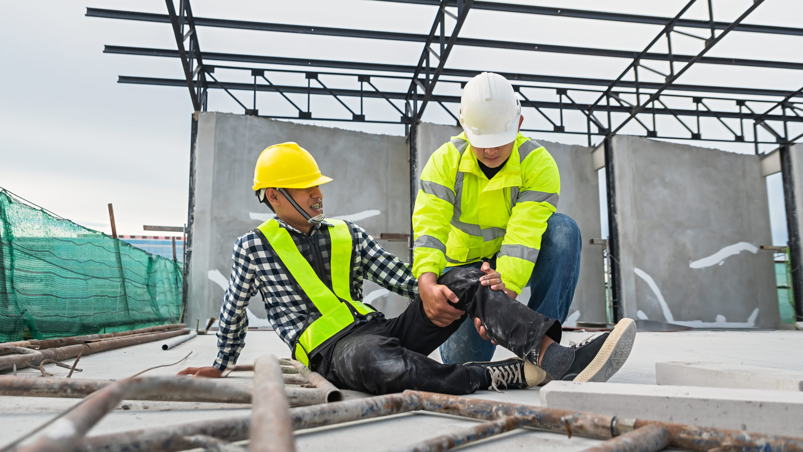 Workers at construction sites fall from heights, fall from scaffolding, injure their knees. with construction supervision engineers hurrying to help first aid in the first place Accidents at work.