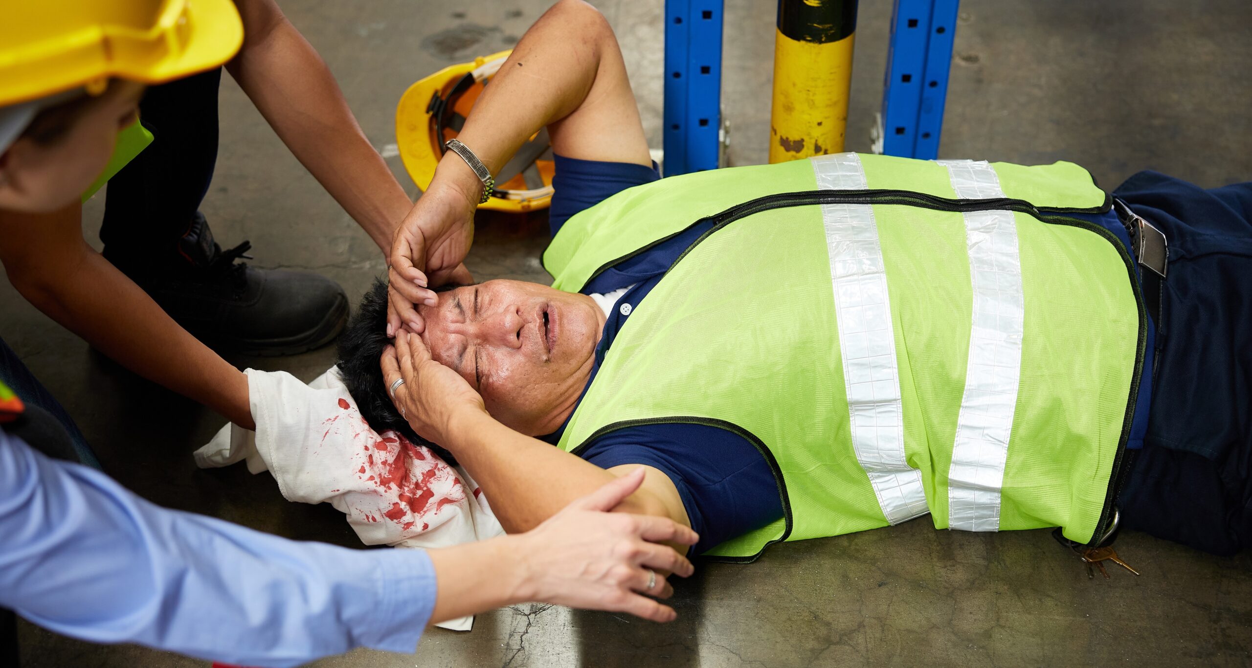 senior worker fell over and his head is bleeding on the floor in the factory