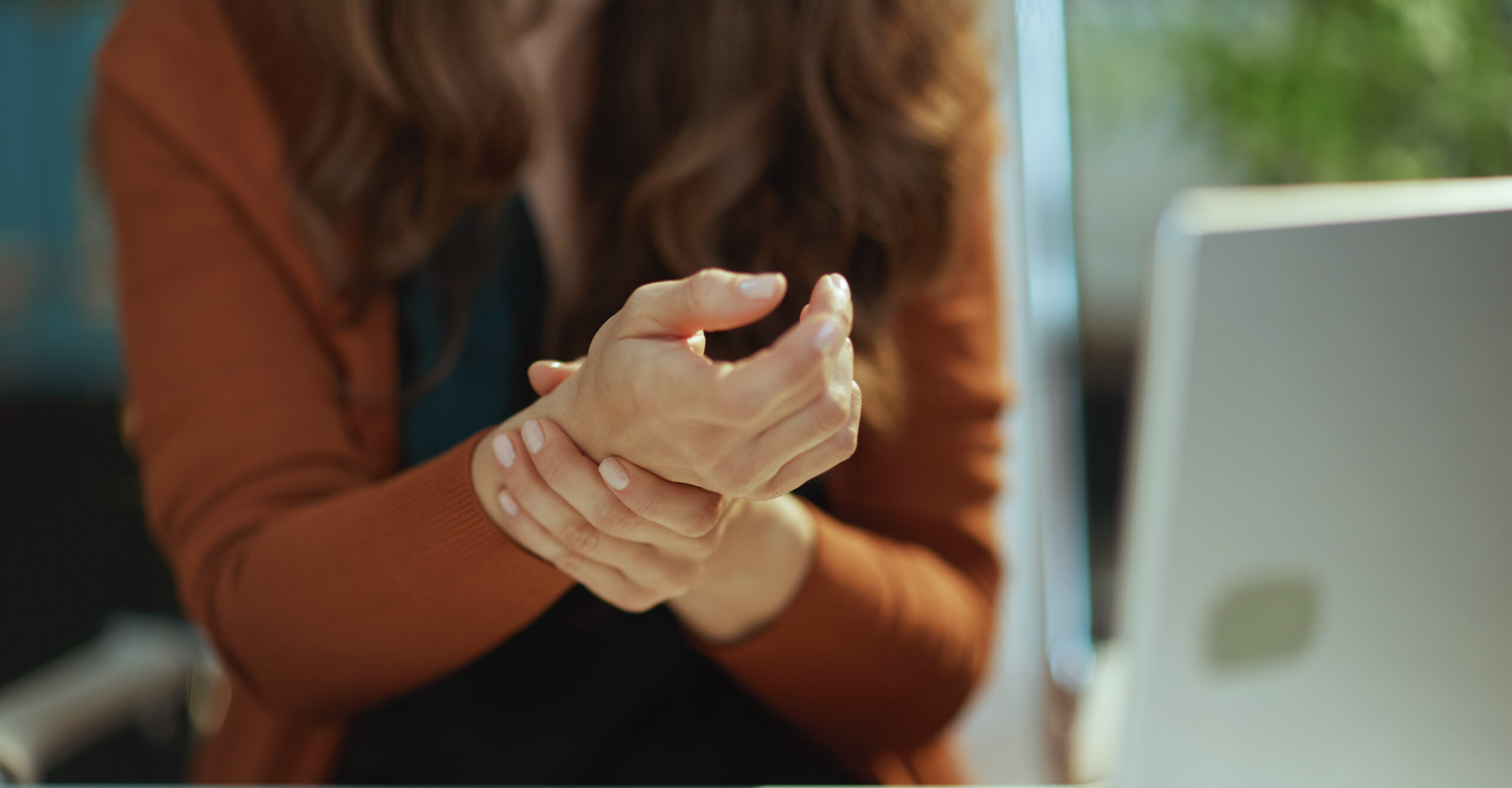 Business owner woman in green office experience carpal syndrome