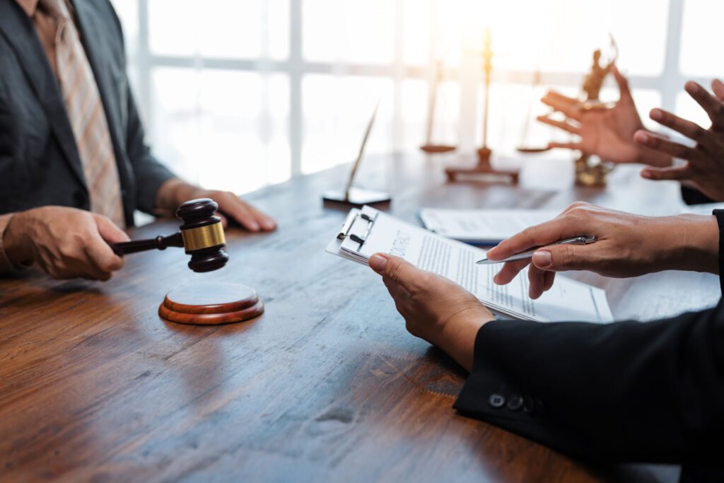 Judge holding gavel during a legal consultation with lawyers in the courtroom
