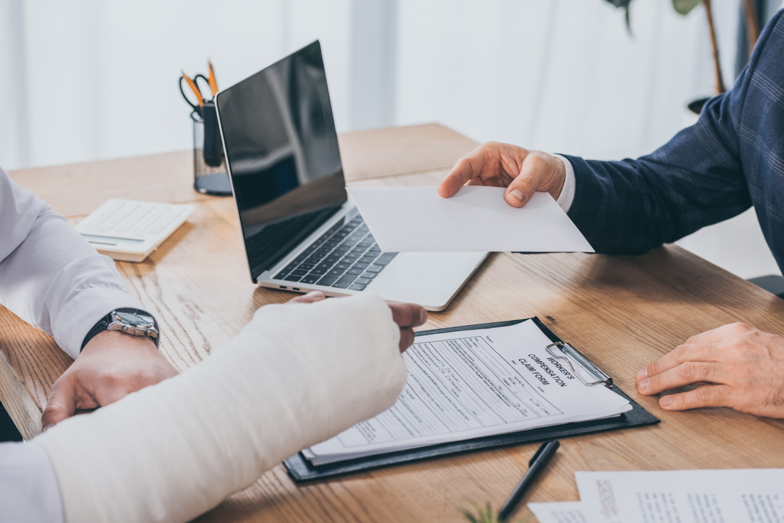 cropped view of businessman sitting at table and giving paper sh cropped view of businessman sitting at table and giving paper sh